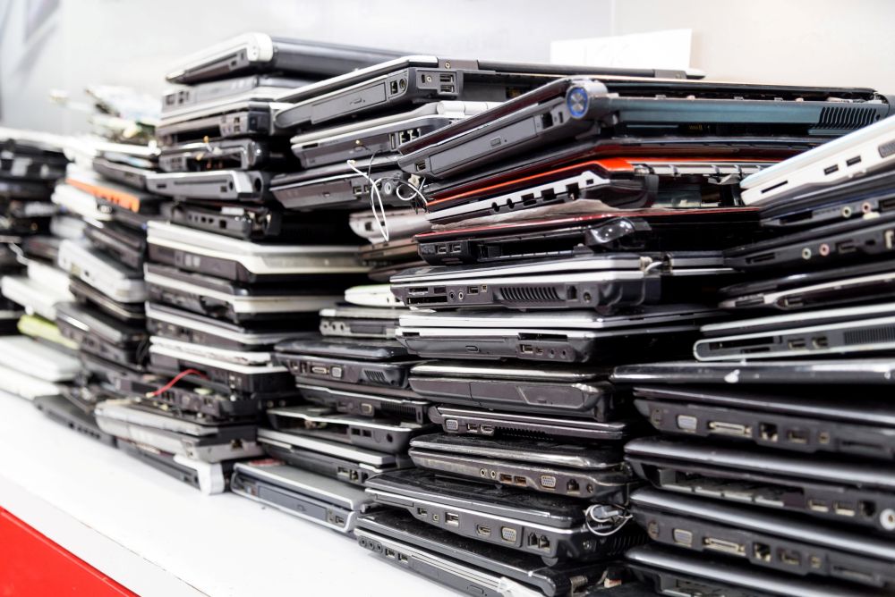 Stacked laptops and electronics ready for responsible recycling (placeholder image).